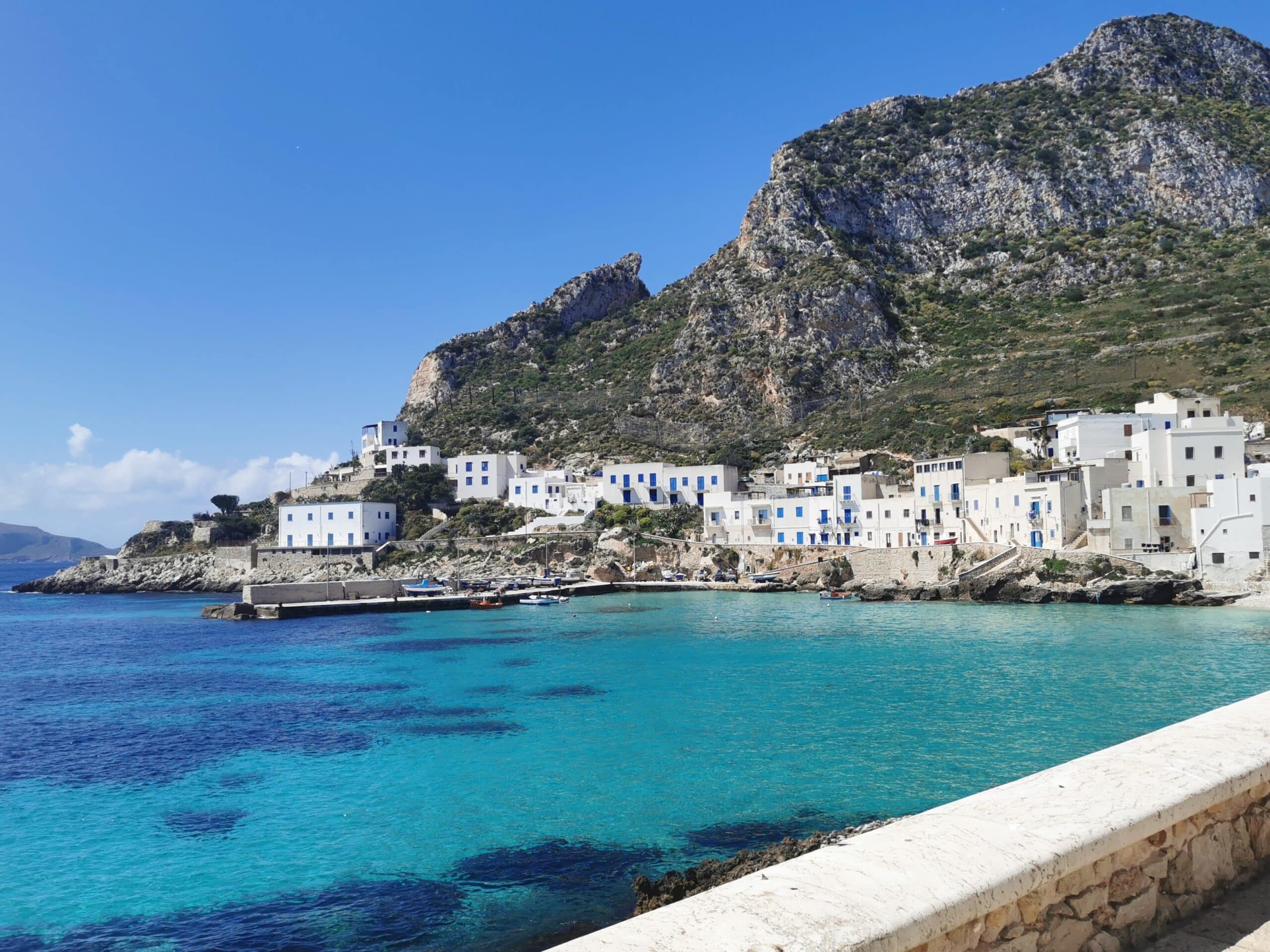 Isola di Levanzo vista dal mare con il borgo di Cala Dogana e acqua turchese
